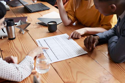 Personer pekar på ett dokument.